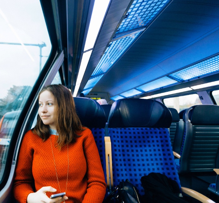 A woman on a train reflects on her retirement journey, emphasizing the need for effective savings to ensure affordability in later years